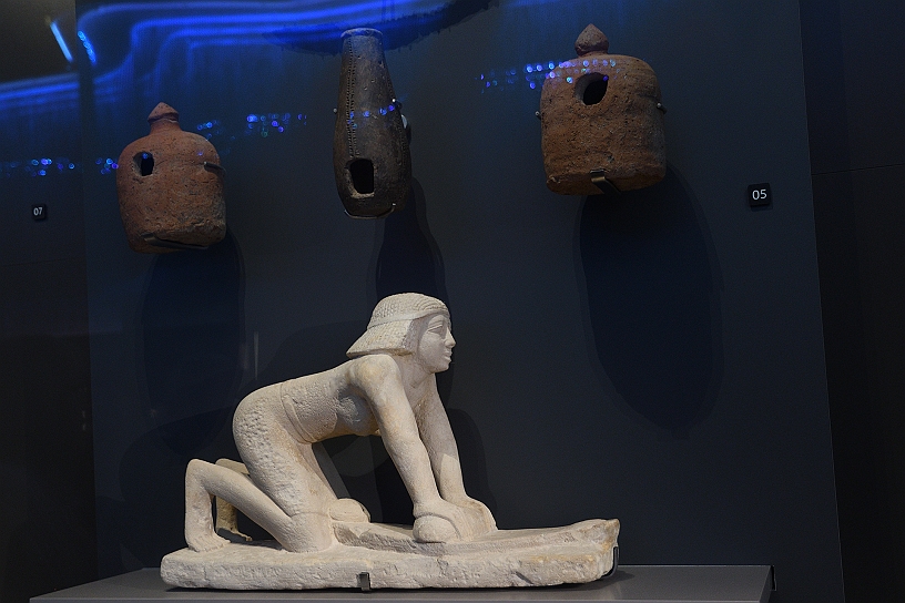 35 MAK_7082.jpg - Statuetta di una persona intenta a macinare il grano utilizzando una macina in pietra, un'attività fondamentale per la produzione del pane nell'antico Egitto.